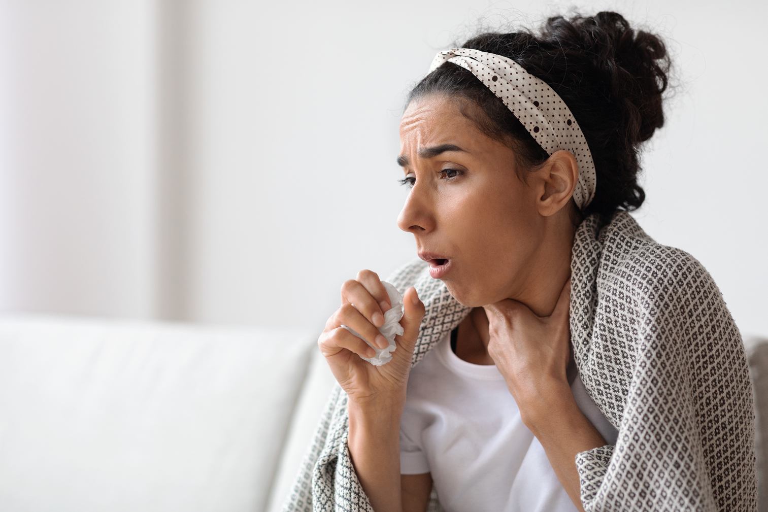 woman-covered-in-blanket-coughing-home-covid-19-wellnest